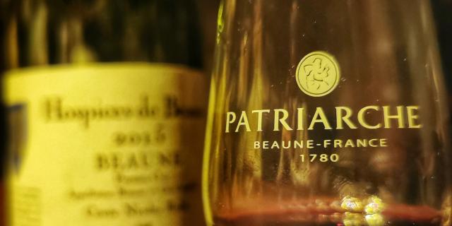 Ein Glas und eine Flasche für eine Weinprobe in den Patriarche-Kellern in Beaune