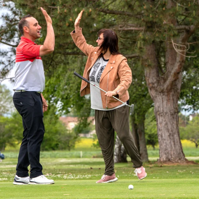 deux personnes de tapant dans la main pendant une partie de golf