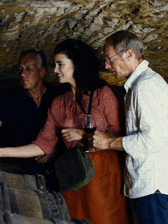 personnes dans une cave dégustant du vin