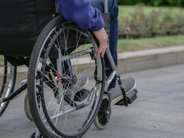 personne en fauteuil roulant se promenant dehors