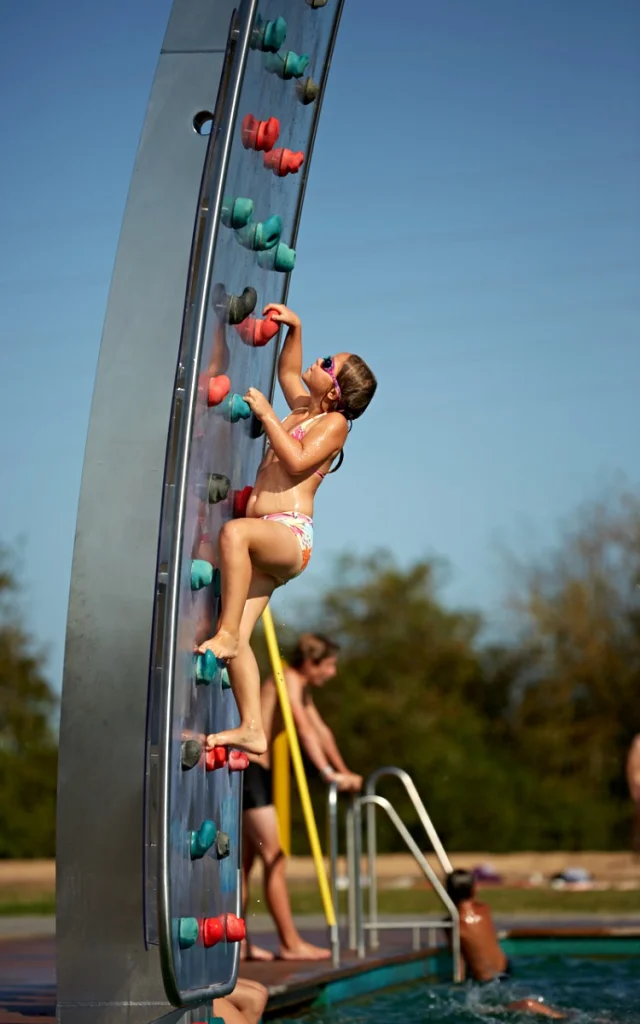 fille grimpant sur un mur d'escalade sur l'eau