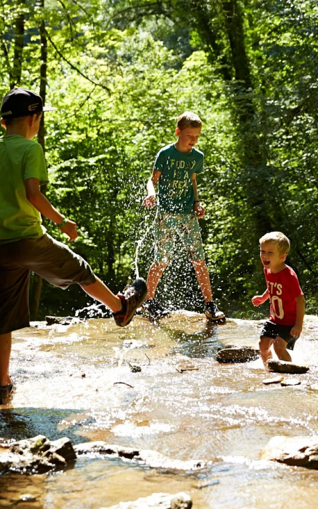 personnes jouant dans un cours d'eau