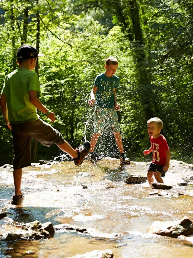 personnes jouant dans un cours d'eau