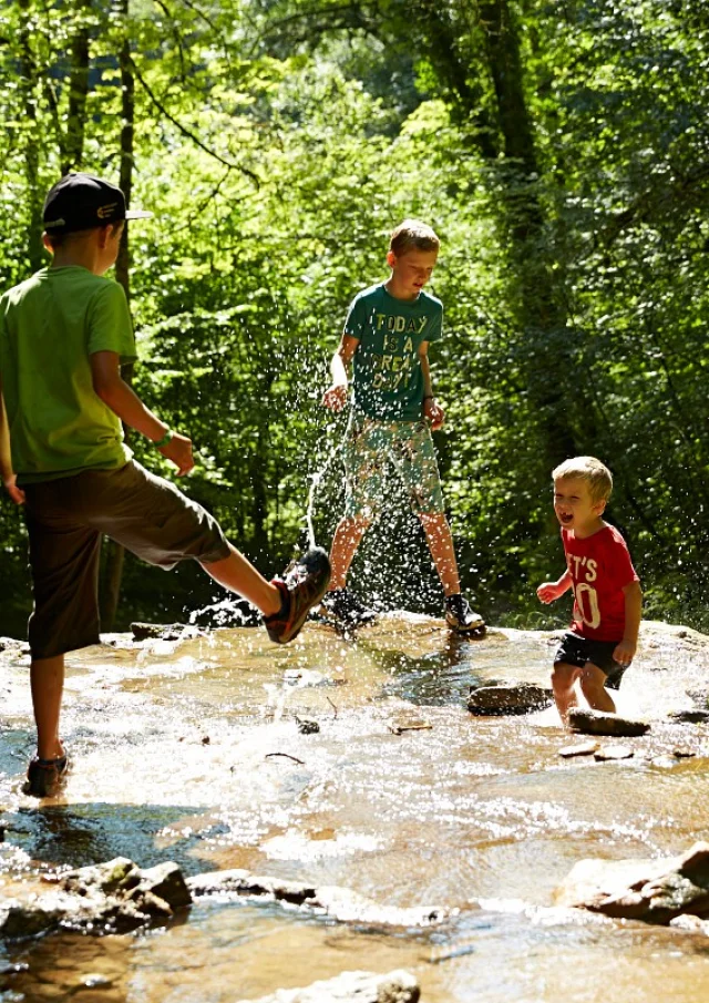 personnes jouant dans un cours d'eau