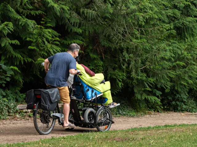 Personne à vélo avec fauteuil roulant