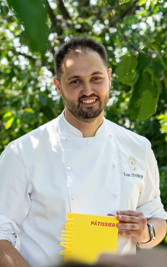Chef assis en extérieur, trophé en main