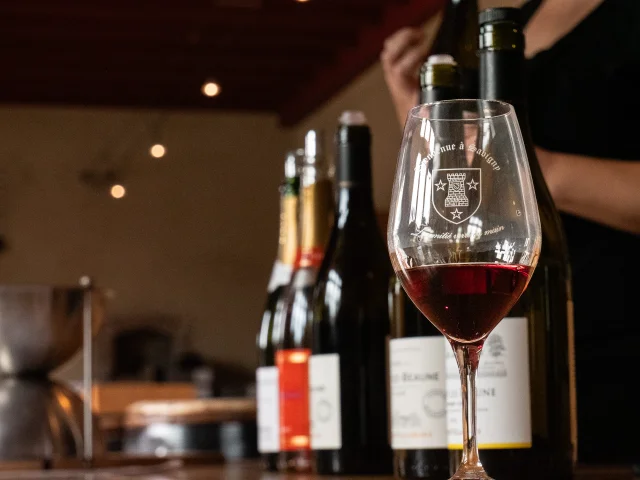 Bienvenue à Savigny, verre et bouteilles de vin sur un comptoir