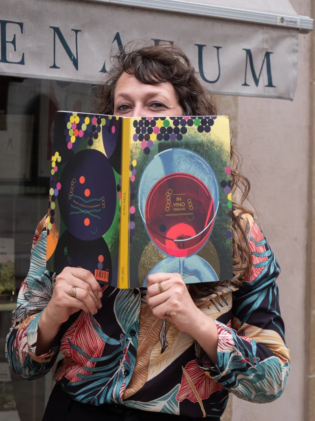 femme devant l'athénaeum avec un livre dans les mains